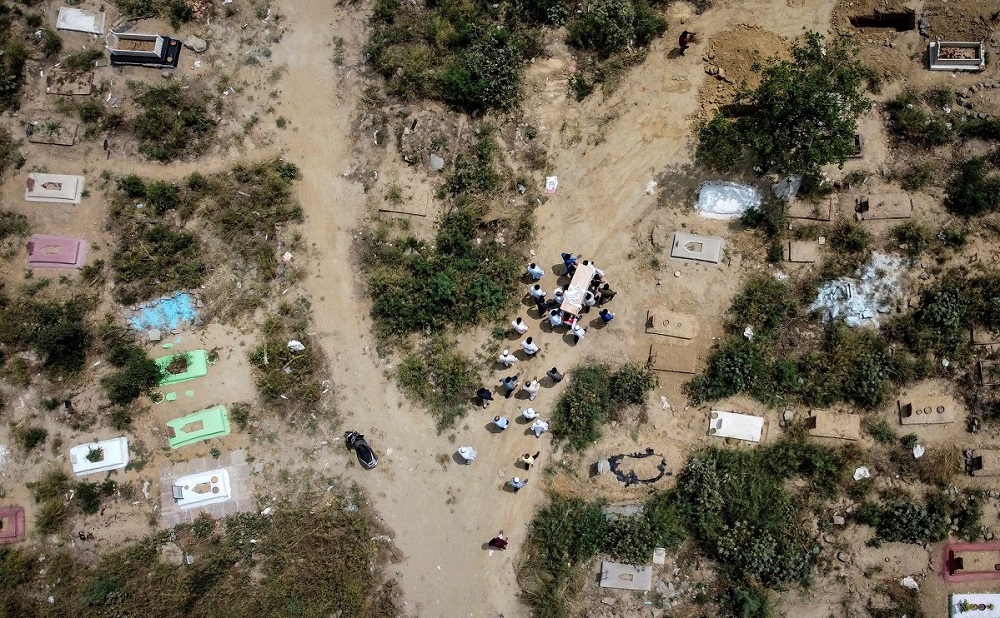 A picture taken with a drone shows people carrying the body of a man who died due to the coronavirus disease (COVID-19), for the burial at a graveyard in New Delhi